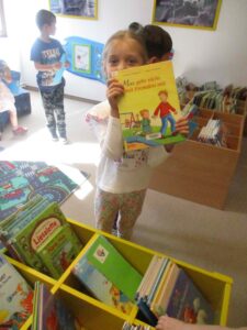 ein Mädchen zeigt ein Kinderbuch