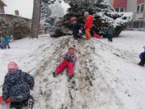 Winterzeit - Kinder rutschen einen Hügel herunter