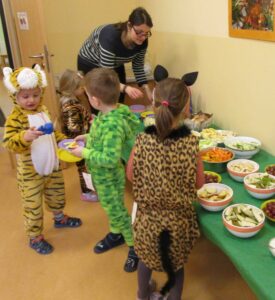 Kinder stehen am Buffet mit gesundem Essen