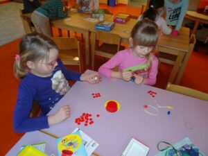 2 Mädchen spielen mit Würfeln am Tisch