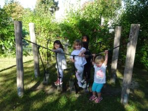 4 Kinder draußen auf einer kleinen Hängebrücke