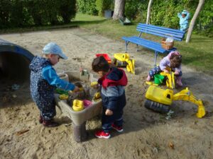 mehrere Kinder spielen im Sandkasten