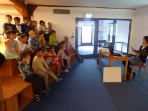 mehrere Kinder hören einer Geschichte der Erzieherin zu