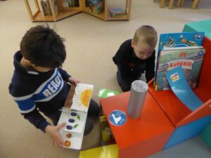 2 Kinder schauen sich Bücher an