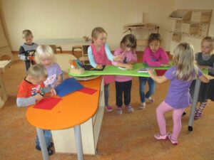 mehrere Kinder basteln mit Buntpapier