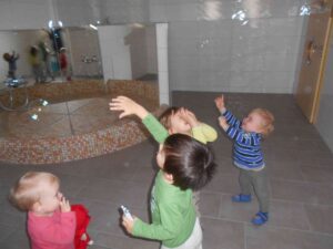 mehrere kleine Kinder haben Spaß mit Seifenblasen