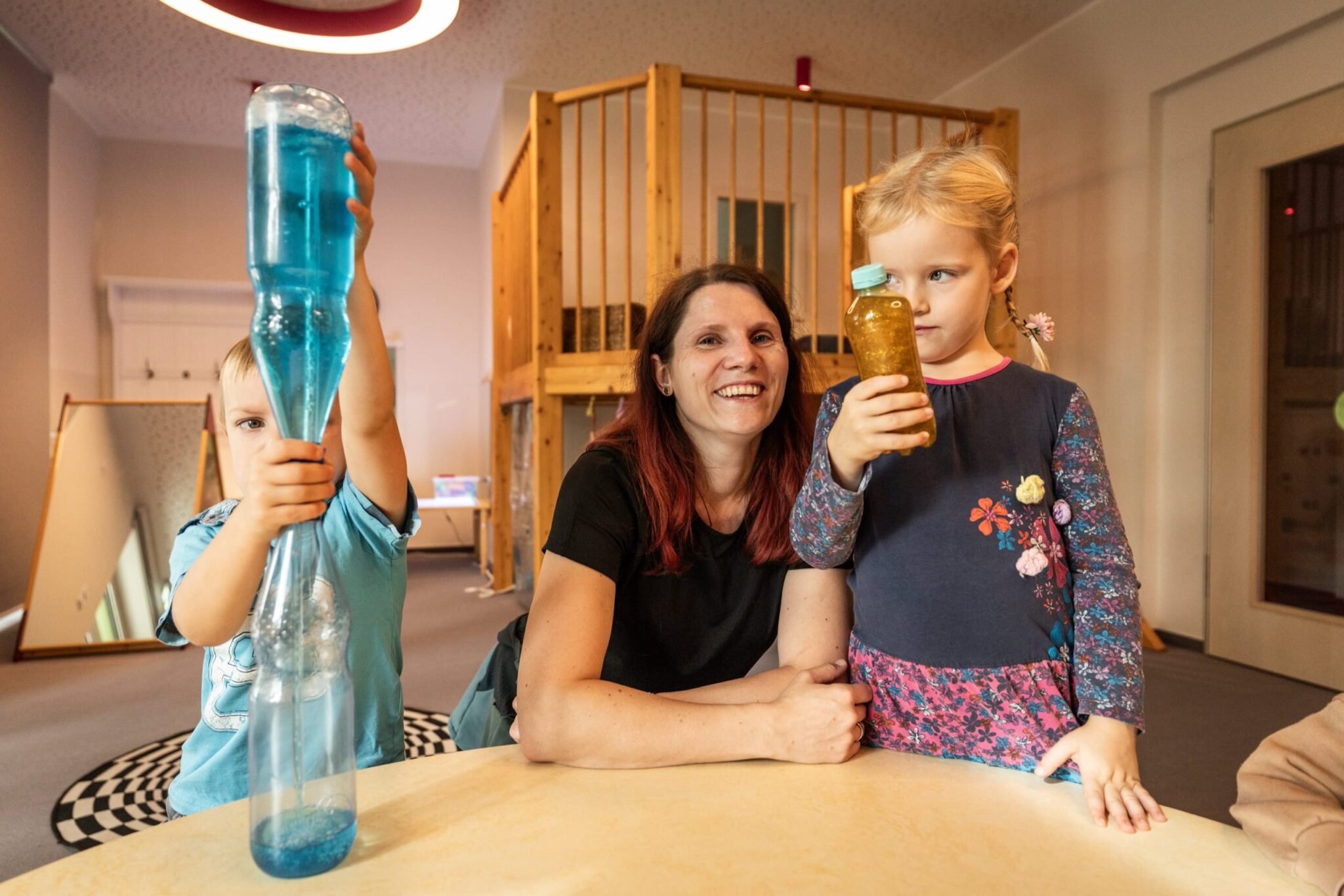 2 Kinder und eine lächelende Erzieherin