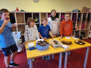 Kinder posieren vor ihren selbst gebackenen Kuchen.