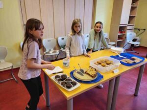Kinder posieren vor ihren selbst gebackenen Kuchen.