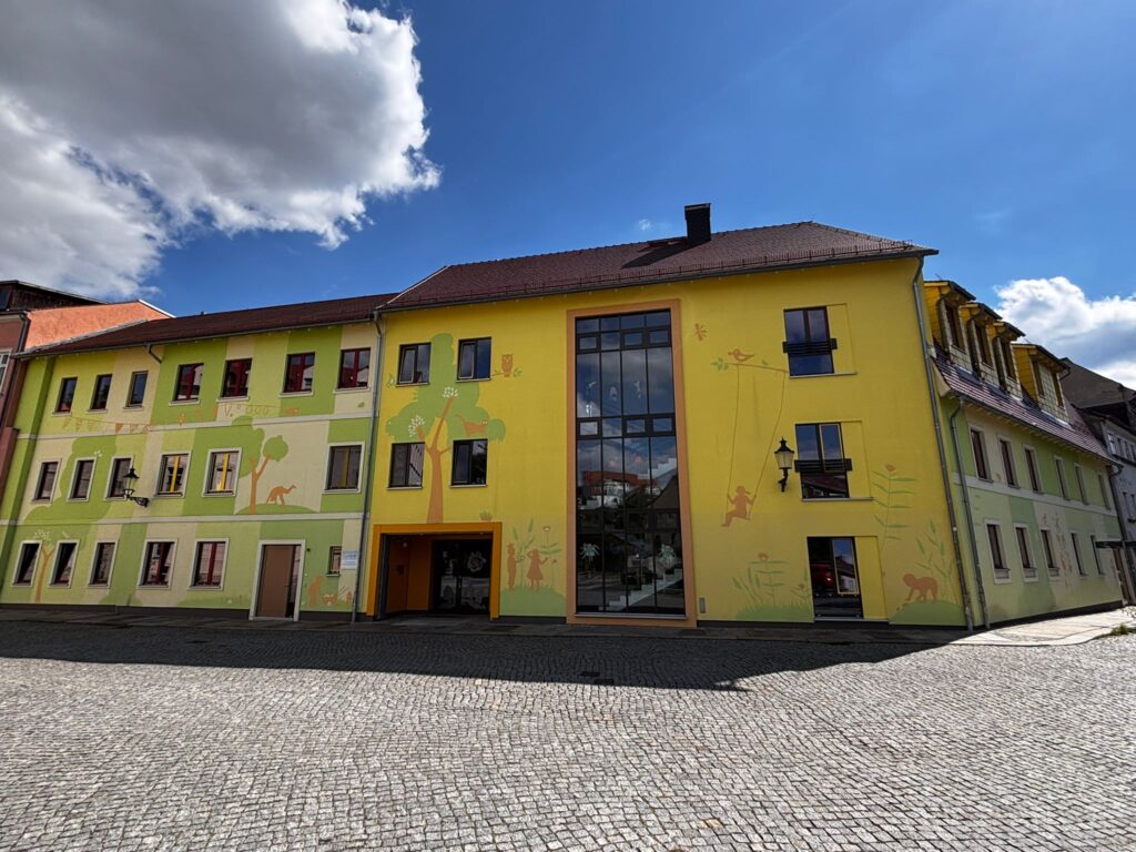 Außenansicht Kita Kleine Stadtentdecker mit strahlend blauem Himmel