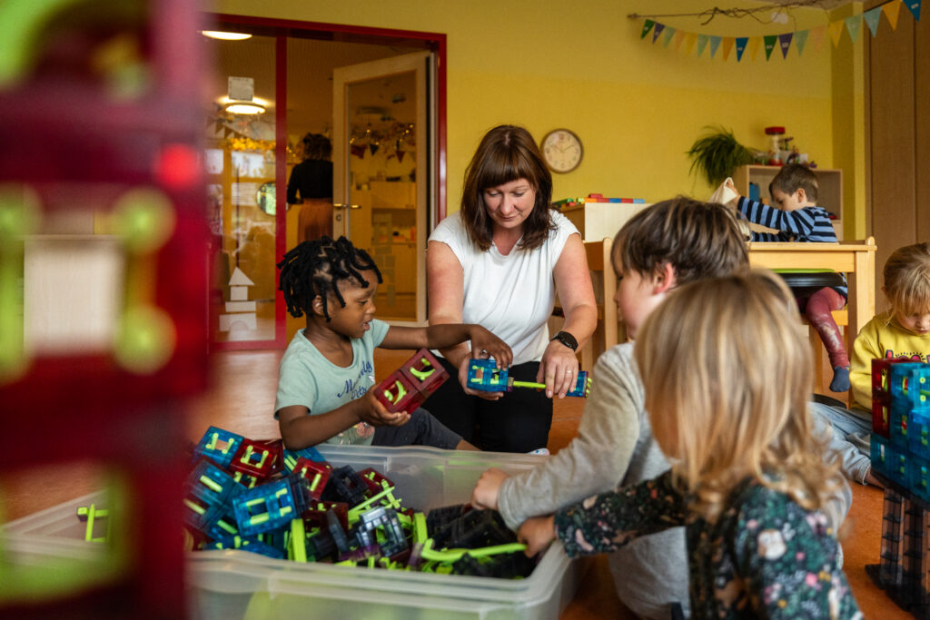 Eine Erzieherin mit spielenden Kindern.